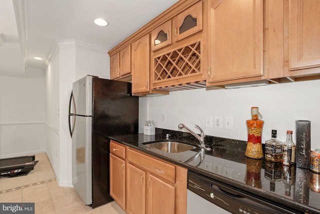 kitchen featuring ornamental molding, a sink, dark stone countertops, freestanding refrigerator, and dishwasher