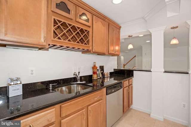 kitchen with dark stone countertops, ornate columns, a sink, stainless steel dishwasher, and crown molding