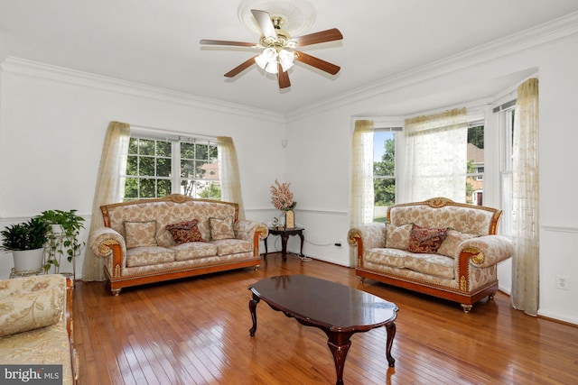 living area featuring a wealth of natural light, crown molding, and hardwood / wood-style flooring