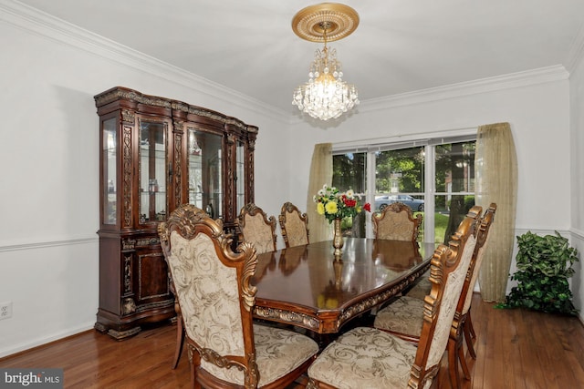 dining space featuring a chandelier, crown molding, and hardwood / wood-style floors