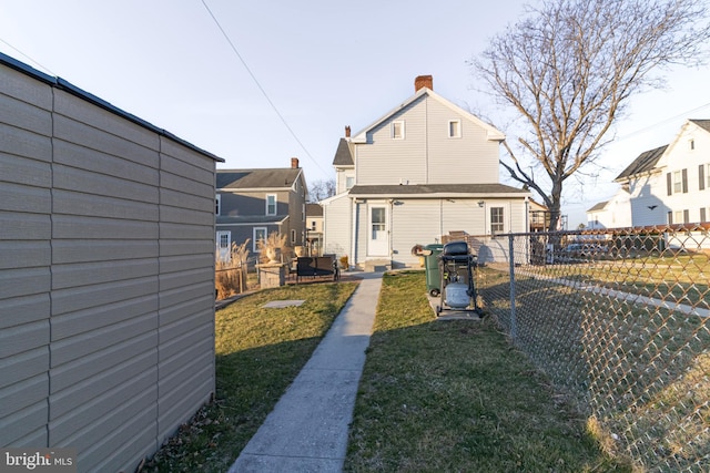 back of house with fence and a lawn