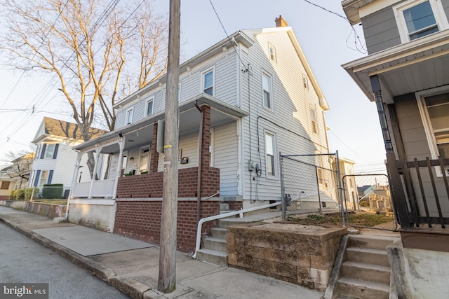 view of side of property with a porch and brick siding