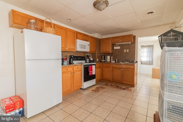 kitchen with a drop ceiling, white appliances, and backsplash