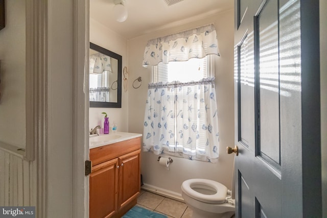 half bath featuring tile patterned floors, visible vents, toilet, and vanity