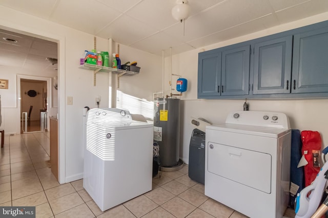 clothes washing area with light tile patterned floors, cabinet space, and electric water heater