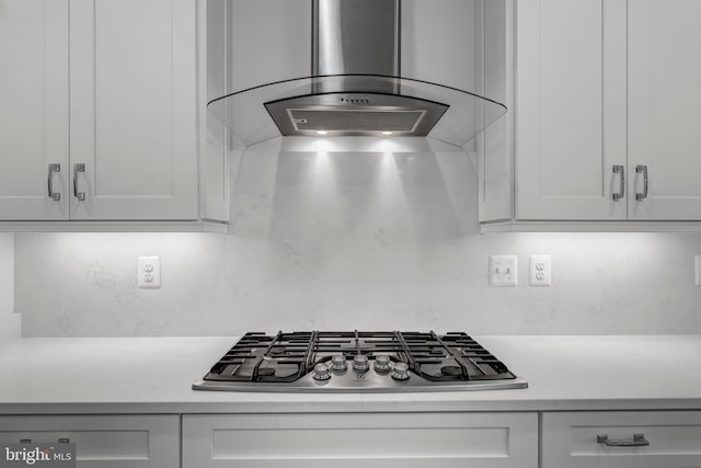 room details featuring white cabinets, light countertops, extractor fan, and stainless steel gas stovetop