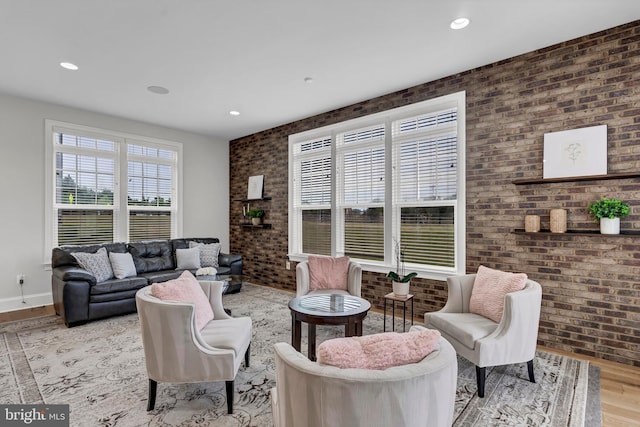 living room with recessed lighting, brick wall, baseboards, and wood finished floors