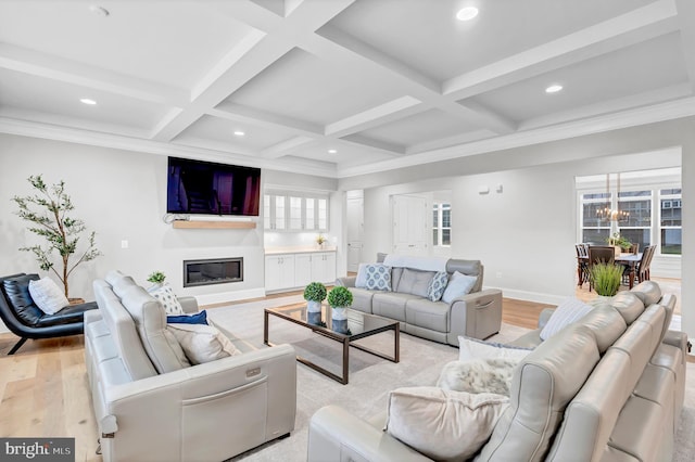 living area with a glass covered fireplace, light wood-style flooring, beamed ceiling, and coffered ceiling