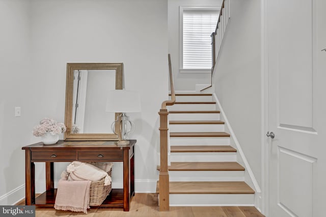 staircase with wood finished floors and baseboards