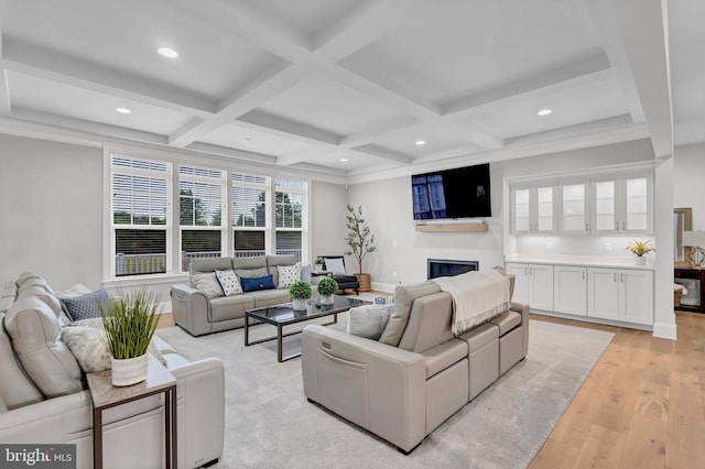 living room with coffered ceiling, recessed lighting, a glass covered fireplace, beamed ceiling, and light wood-type flooring