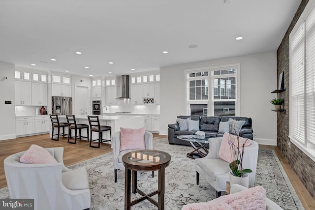 living room featuring recessed lighting, light wood-type flooring, and baseboards