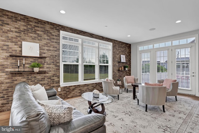 living room featuring recessed lighting, wood finished floors, and brick wall