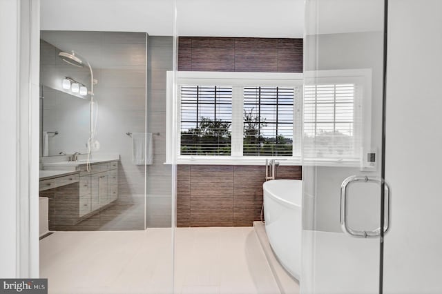 bathroom with a shower with shower door, a soaking tub, vanity, and tile patterned flooring