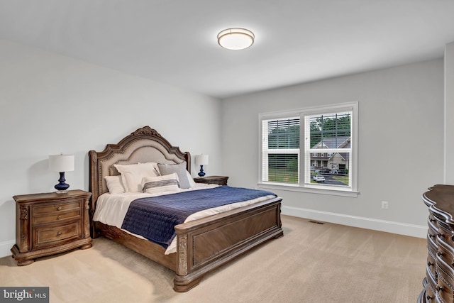 bedroom with light colored carpet, visible vents, and baseboards