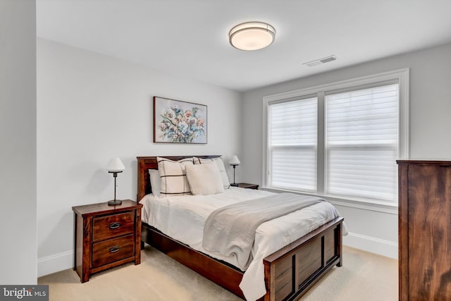 bedroom featuring visible vents, baseboards, and light colored carpet