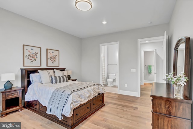 bedroom with recessed lighting, light wood-style floors, baseboards, and ensuite bathroom