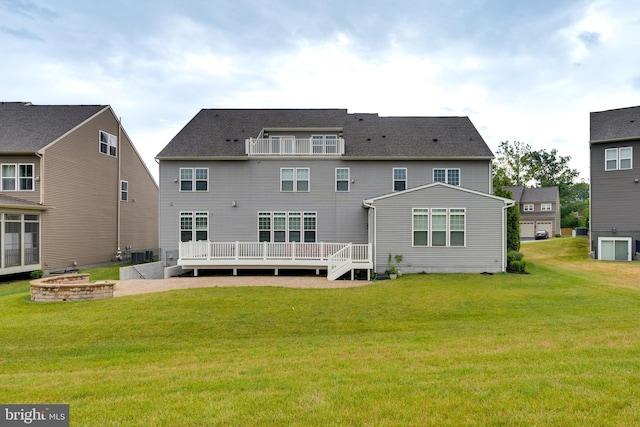 rear view of house featuring central AC unit, a lawn, and a wooden deck