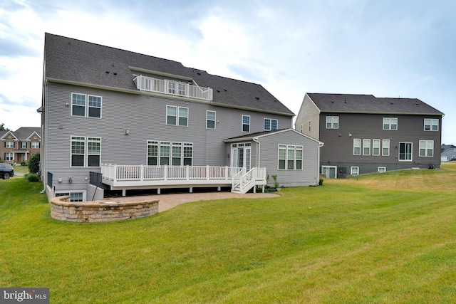 rear view of property featuring a yard and a wooden deck