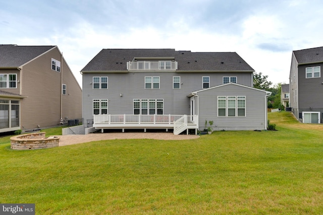 back of property with a deck, a lawn, a patio, and central AC