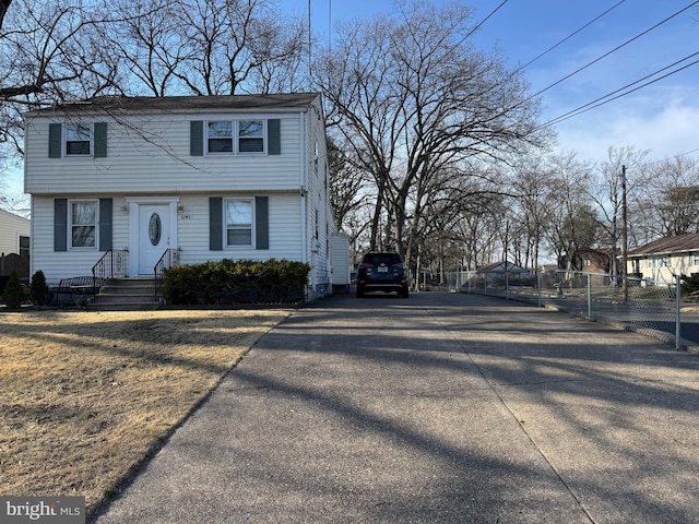 view of front of home with aphalt driveway and fence