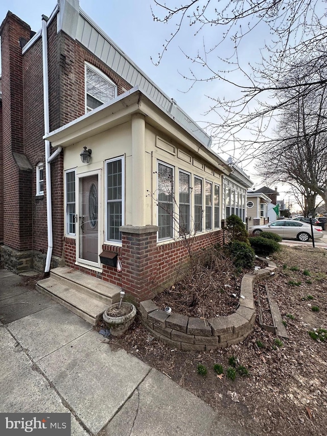 view of property exterior with entry steps and brick siding