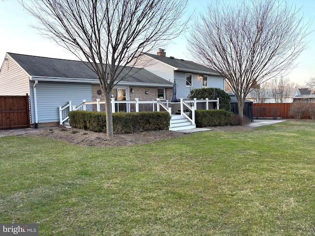 back of house with a lawn and fence