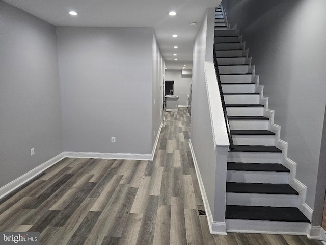 stairway featuring recessed lighting, baseboards, and wood finished floors