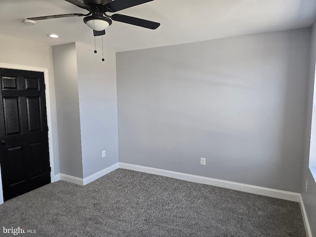 carpeted spare room featuring baseboards and ceiling fan