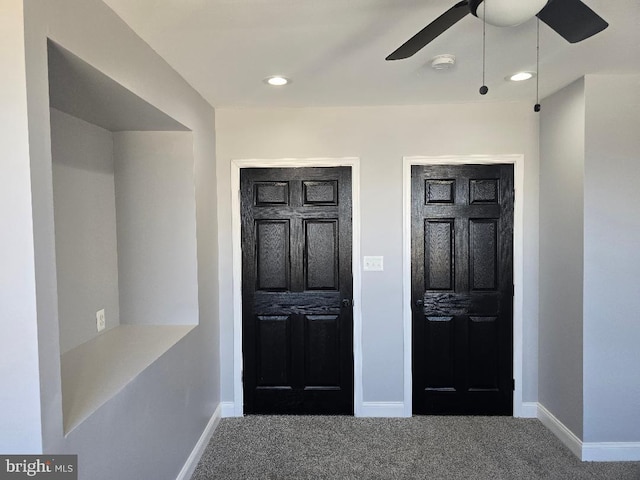 foyer entrance with a ceiling fan, baseboards, and carpet floors