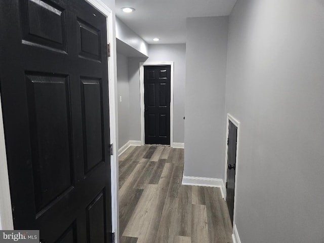 hall featuring recessed lighting, baseboards, and dark wood-style flooring