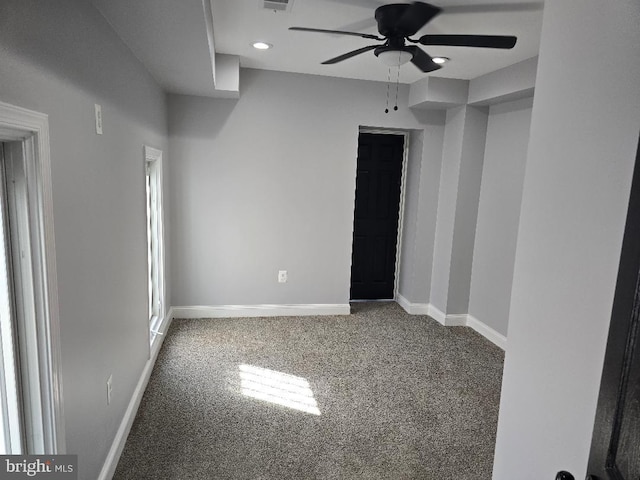 empty room featuring visible vents, a ceiling fan, baseboards, and carpet floors