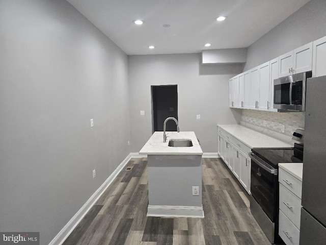 kitchen with backsplash, dark wood-type flooring, an island with sink, appliances with stainless steel finishes, and a sink