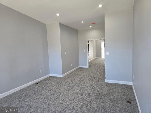 empty room with carpet flooring, recessed lighting, visible vents, and baseboards