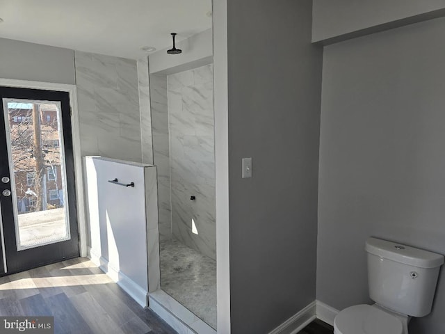 full bath featuring a marble finish shower, a healthy amount of sunlight, and toilet