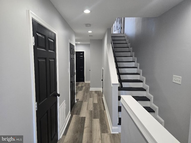 stairway with recessed lighting, baseboards, and wood finished floors