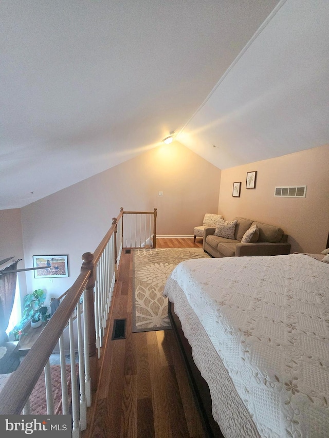 bedroom featuring vaulted ceiling, visible vents, and wood finished floors