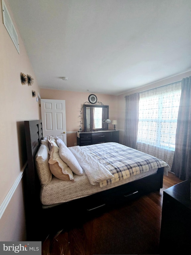 bedroom with visible vents and dark wood-style flooring