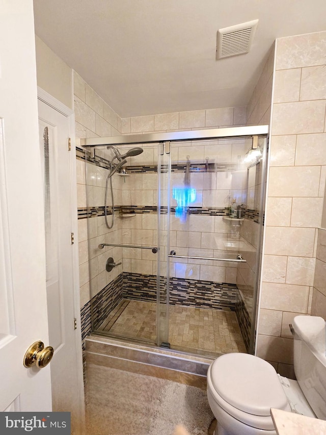 bathroom featuring visible vents, a shower stall, and toilet