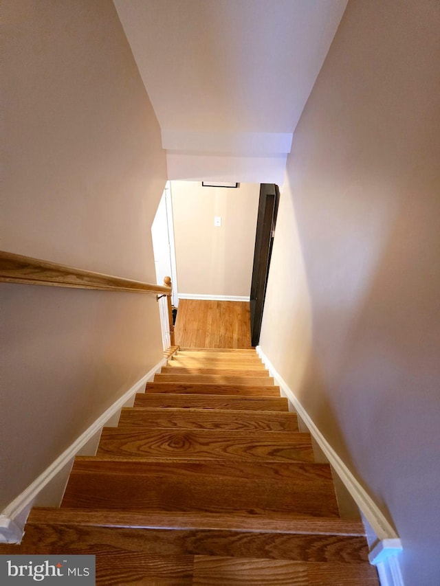 staircase with wood finished floors and baseboards