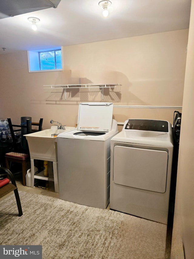 laundry room featuring a sink, laundry area, and washer and clothes dryer