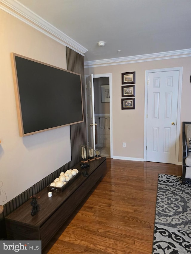 living room featuring baseboards, wood finished floors, and crown molding