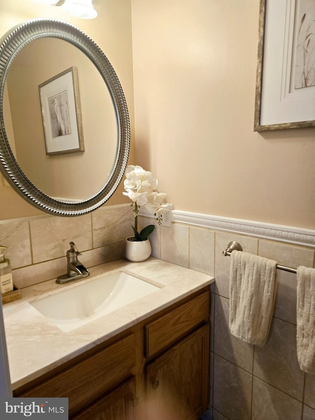 bathroom with wainscoting, vanity, and tile walls