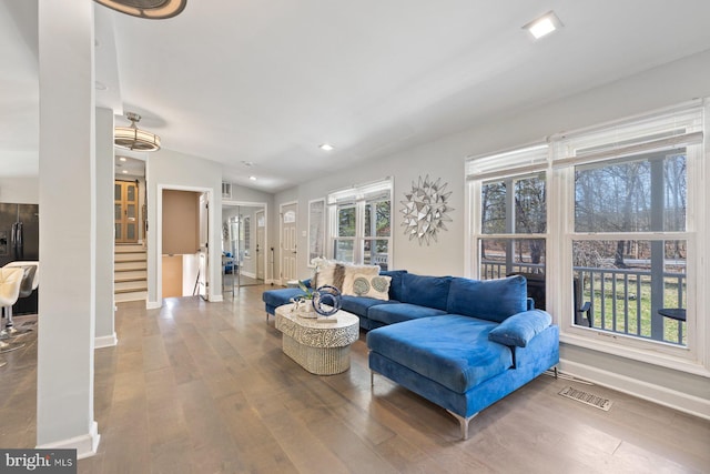 living room with visible vents, stairs, lofted ceiling, and wood finished floors