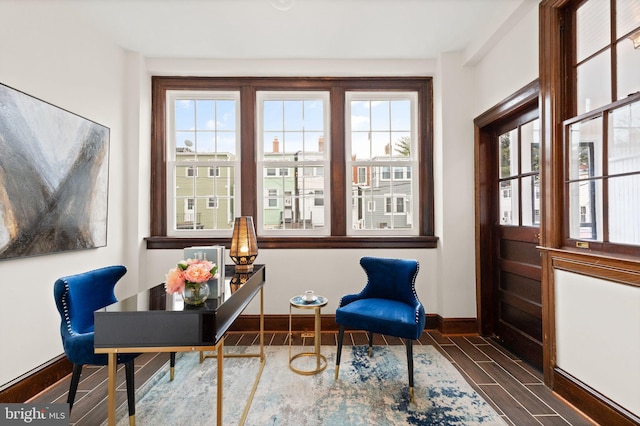 living area featuring baseboards and wood tiled floor