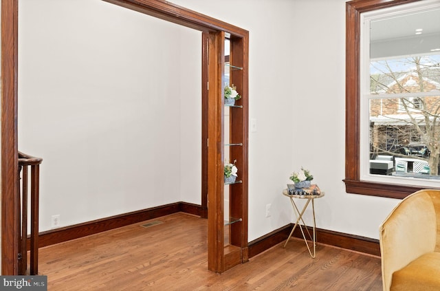 living area featuring visible vents, wood finished floors, and baseboards