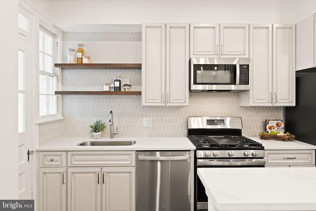 kitchen featuring plenty of natural light, appliances with stainless steel finishes, light countertops, and a sink