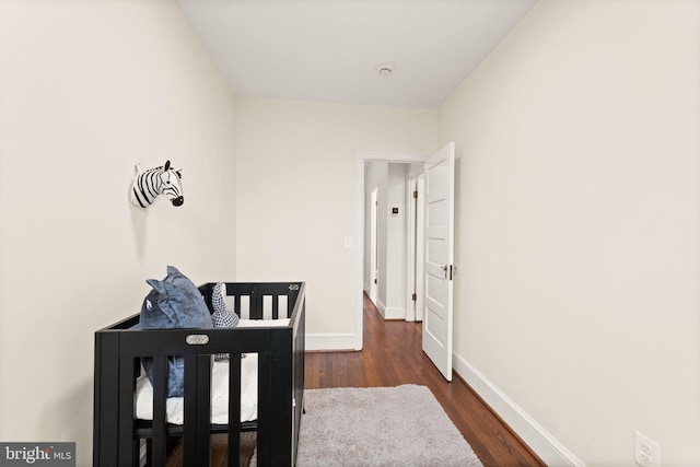 hall featuring dark wood-type flooring and baseboards