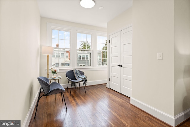 living area featuring baseboards and wood-type flooring