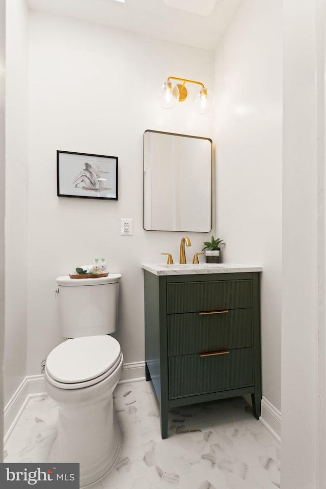 bathroom featuring marble finish floor, toilet, vanity, and baseboards