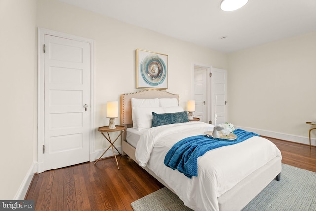 bedroom with baseboards and dark wood-style flooring